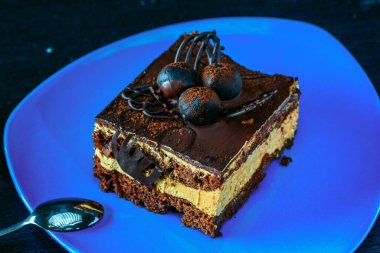 Tahta bir arka planda yakın plan çekilmiş bir parça çikolatalı pasta..