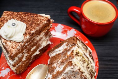 Kremalı ekşi pasta ve kırmızı bardakta taze kahve.