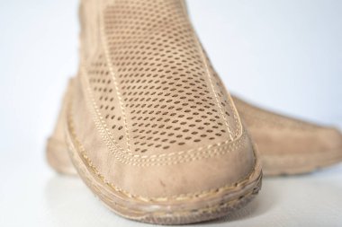 Erkek bej rengi deri ayakkabılar, model mokasenler. Işık arkaplanda yakın plan çekimleri.