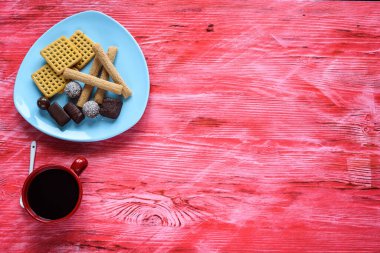 Ev yapımı hamur işleri ve çikolatalar seramik tabakta, ahşap bir arka planda..