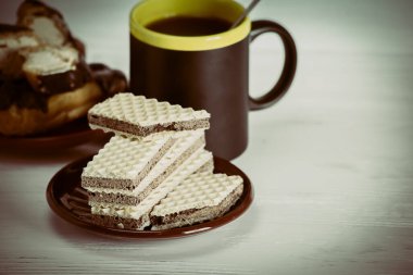 Kahveler, waffle 'lar ve pastalar ahşap arka planda