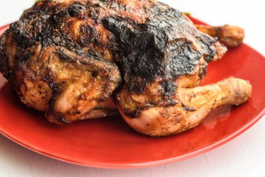Kırmızı tabakta ızgara tavuk.