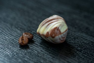 Siyah ahşap arka planda Belçika çikolataları. Fotoğraflı yakın plan..