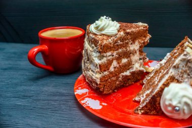 Kremalı ekşi pasta ve kırmızı bardakta taze kahve.