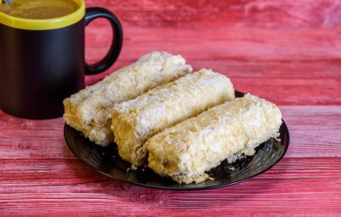 Napolyon kekleri kırmızı ahşap arka planda bir fincan kahve.