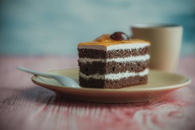 Tahta bir arka planda, bir tabakta duran sünger keki..