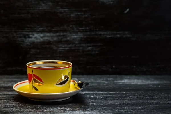 Tee Einem Gelben Becher Auf Schwarzem Holzgrund — Stockfoto
