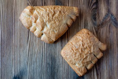 Ev yapımı muhallebi profiteroller ahşap bir arka planda serili.