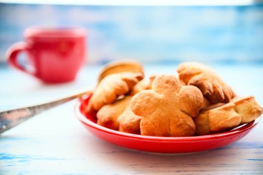 Kırmızı tabakta kurabiye ve kırmızı fincanda kahve.