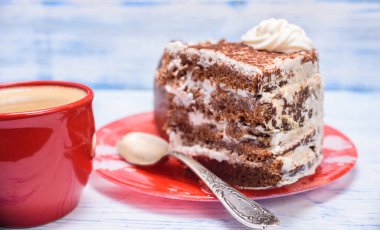 Kremalı ekşi pasta ve kırmızı bardakta taze kahve.