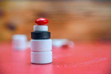 Kırmızı arkaplanda tıbbi tabletlerden oluşan bir sütun