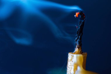 Karanlık bir arka planda sönmüş bir mumdan duman..