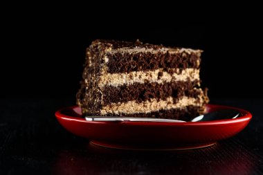 Bir parça çikolatalı kek ve üzerinde çikolata olan kurabiyeler.