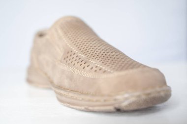 Erkek bej rengi deri ayakkabılar, model mokasenler. Işık arkaplanda yakın plan çekimleri.