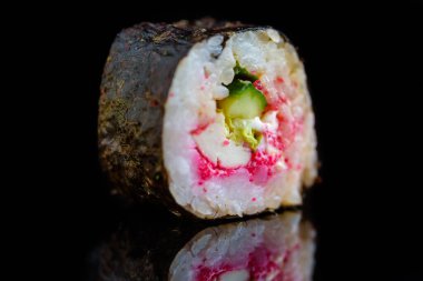 Suşi rulosu koyu bir arkaplanda izole edilmiş..