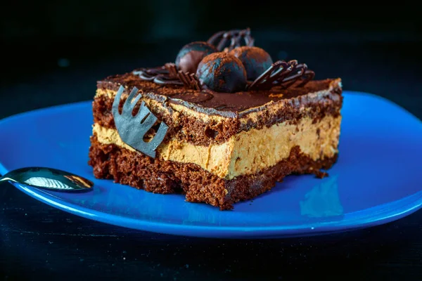 Pezzo Torta Cioccolato Piatto Blu Uno Sfondo Legno — Foto Stock