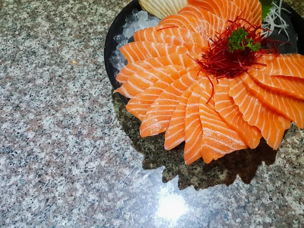 Raw salmon slice or salmon sashimi in Japanese style fresh serve on ice in bowl.