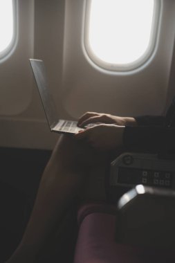 Sarışın kadın turist gelen bildirim netbook ile uçak koltuğunda oturan Smartphone cep telefonu ile kontrol. Genç işkadını paylaşmak medya telefonu dizüstü bilgisayar üzerinde uçak uçuş sırasında