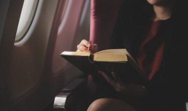 Sarışın kadın turist gelen bildirim netbook ile uçak koltuğunda oturan Smartphone cep telefonu ile kontrol. Genç işkadını paylaşmak medya telefonu dizüstü bilgisayar üzerinde uçak uçuş sırasında