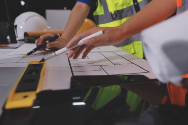 Endüstriyel mühendislerden oluşan bir ekip, fabrikadaki masada bulunan makine planlarını analiz ediyor. Fabrikada ya da üretim tesisinde çalışıyorum..