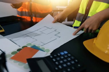 Endüstriyel mühendislerden oluşan bir ekip, fabrikadaki masada bulunan makine planlarını analiz ediyor. Fabrikada ya da üretim tesisinde çalışıyorum..