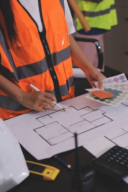 Endüstriyel mühendislerden oluşan bir ekip, fabrikadaki masada bulunan makine planlarını analiz ediyor. Fabrikada ya da üretim tesisinde çalışıyorum..