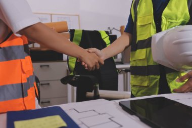 Endüstriyel mühendislerden oluşan bir ekip, fabrikadaki masada bulunan makine planlarını analiz ediyor. Fabrikada ya da üretim tesisinde çalışıyorum..