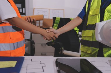 Endüstriyel mühendislerden oluşan bir ekip, fabrikadaki masada bulunan makine planlarını analiz ediyor. Fabrikada ya da üretim tesisinde çalışıyorum..