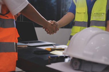 Endüstriyel mühendislerden oluşan bir ekip, fabrikadaki masada bulunan makine planlarını analiz ediyor. Fabrikada ya da üretim tesisinde çalışıyorum..