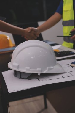 Endüstriyel mühendislerden oluşan bir ekip, fabrikadaki masada bulunan makine planlarını analiz ediyor. Fabrikada ya da üretim tesisinde çalışıyorum..