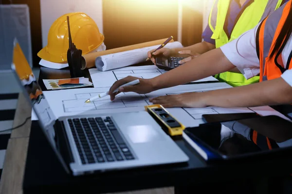 Endüstriyel mühendislerden oluşan bir ekip, fabrikadaki masada bulunan makine planlarını analiz ediyor. Fabrikada ya da üretim tesisinde çalışıyorum..