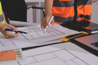 Endüstriyel mühendislerden oluşan bir ekip, fabrikadaki masada bulunan makine planlarını analiz ediyor. Fabrikada ya da üretim tesisinde çalışıyorum..