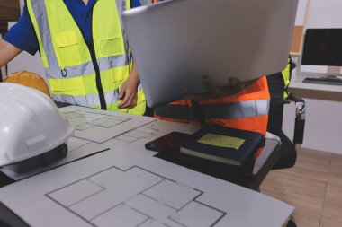 Endüstriyel mühendislerden oluşan bir ekip, fabrikadaki masada bulunan makine planlarını analiz ediyor. Fabrikada ya da üretim tesisinde çalışıyorum..