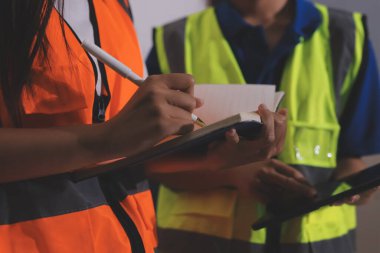 Endüstriyel mühendislerden oluşan bir ekip, fabrikadaki masada bulunan makine planlarını analiz ediyor. Fabrikada ya da üretim tesisinde çalışıyorum..