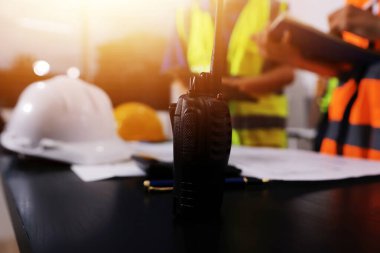Endüstriyel mühendislerden oluşan bir ekip, fabrikadaki masada bulunan makine planlarını analiz ediyor. Fabrikada ya da üretim tesisinde çalışıyorum..