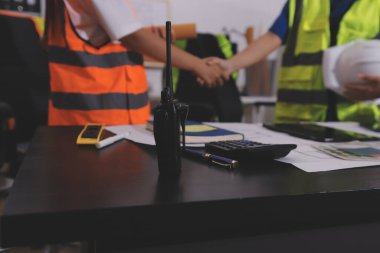 Endüstriyel mühendislerden oluşan bir ekip, fabrikadaki masada bulunan makine planlarını analiz ediyor. Fabrikada ya da üretim tesisinde çalışıyorum..