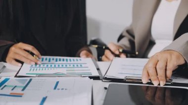 İş adamları bilgisayar üzerinde finansal veriler ve grafiklerle çalışırlar