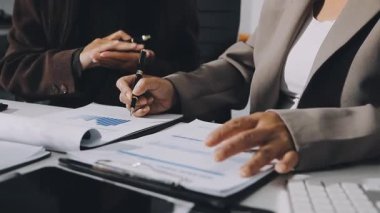 Ofiste belgelerle çalışan genç bir iş kadını.