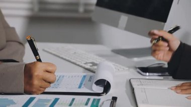 Modern bir ofiste bilgisayar üzerinde çalışan bir iş ekibini kalem ile kapatın..