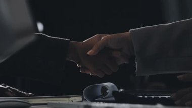 Modern ofiste iş çıkışı iş adamları el sıkışıyor.