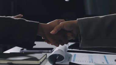 Modern ofisteki iş adamlarının el sıkışması.