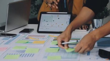 İş adamları mali planı ekrandaki çizelgelerle tartışıyor.