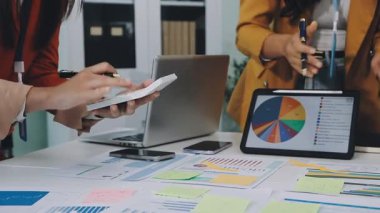 İşyerindeki grafikler ve grafiklerle birlikte dizüstü bilgisayarda çalışan iş kadınını kapat.