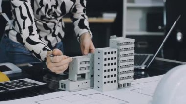 Mimar mühendis ofis binasında ev planı üzerinde çalışıyor.