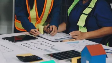 Ofisteki planlarla çalışan bir mimar