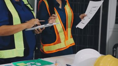 Planlar üzerinde çalışan mühendis ya da mühendis ya da mühendis ve inşaat alanındaki inşaat odasına bakın..