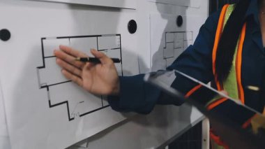 Planla birlikte odada çalışan mühendis..