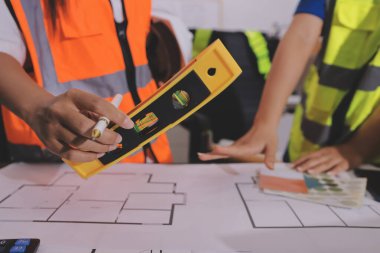 Endüstriyel mühendislerden oluşan bir ekip, fabrikadaki masada bulunan makine planlarını analiz ediyor. Fabrikada ya da üretim tesisinde çalışıyorum..