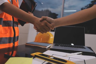 Endüstriyel mühendislerden oluşan bir ekip, fabrikadaki masada bulunan makine planlarını analiz ediyor. Fabrikada ya da üretim tesisinde çalışıyorum..