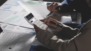 İş adamları, modern iç işlerinde hesap makineleri ve finansal dökümanlar kullanıyorlar.